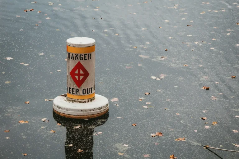 gefahr schild in wasser - Symbol Bild Gewässerschadenhaftpflichtversicherung
